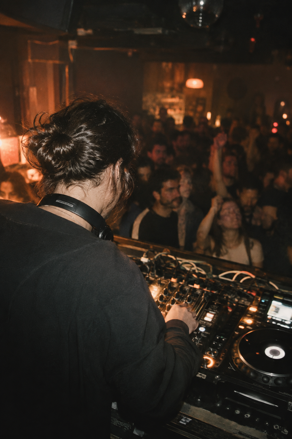 A DJ at the decks, facing the audience